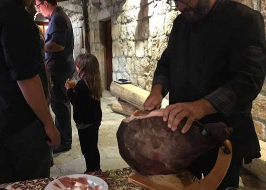 Niko slicing locally cured ham called prsut